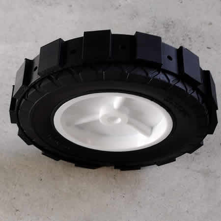Upper side picture of a Green Gripper on a lawn mower wheel. It Black