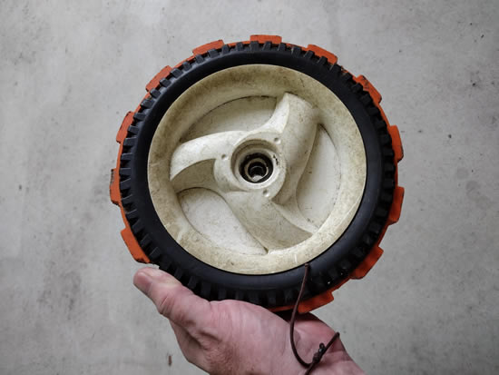 Me holding an 8 inch Green Gripper on a lawn mower wheel